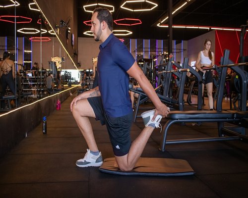 A person doing a slow dynamic stretch in a modern gym